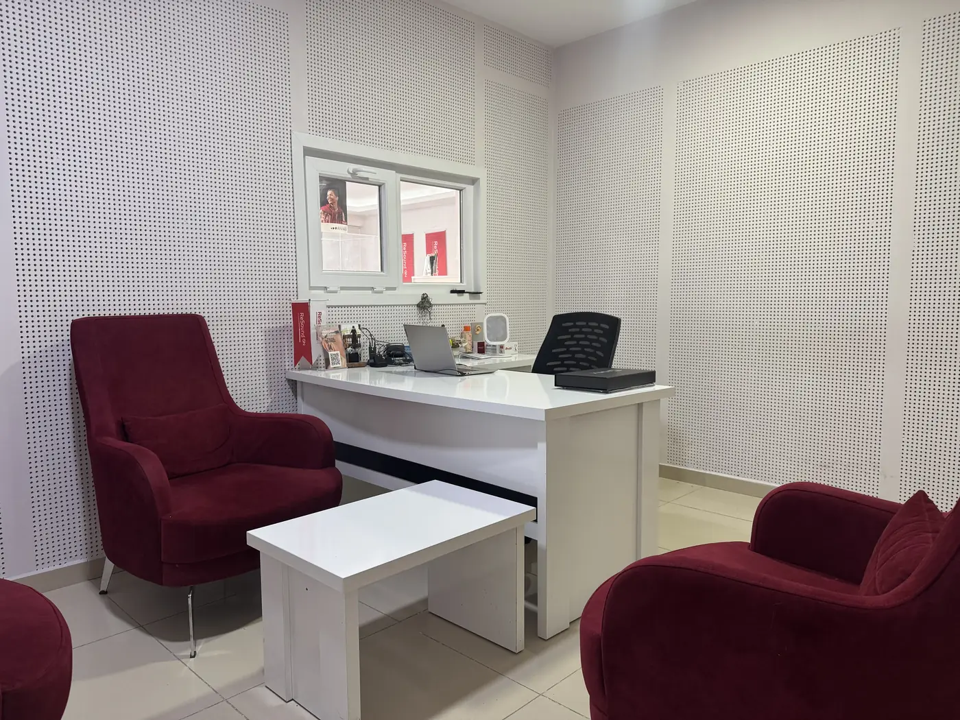 Doruk İşitme Cihazları Mamak Şubesi danışma masası, bordo koltuklar ve dizüstü bilgisayar