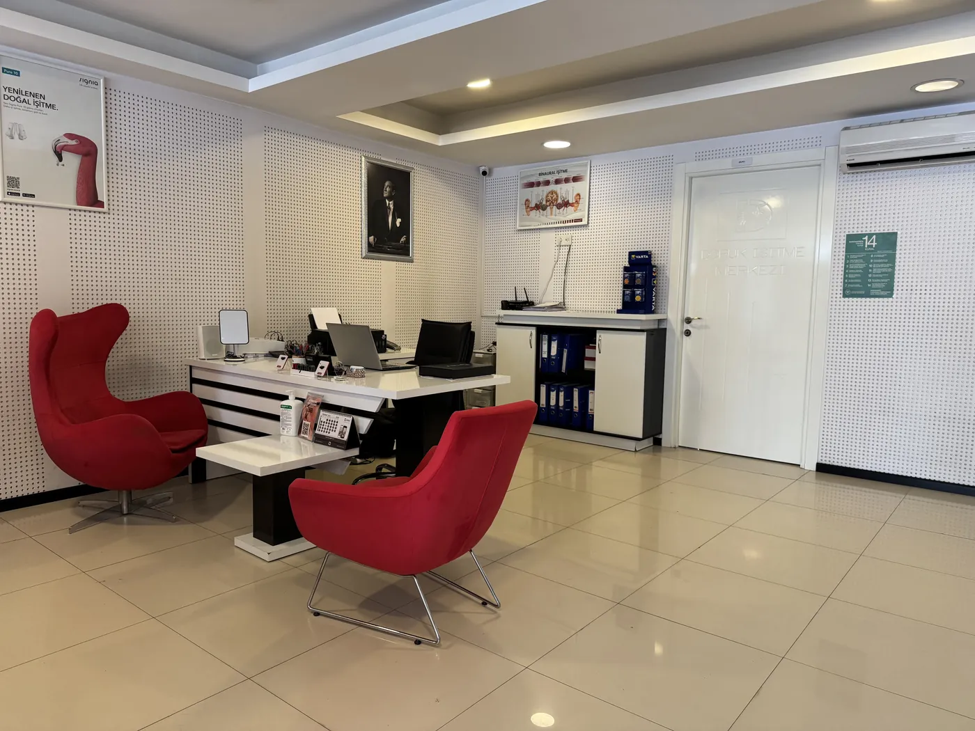 Doruk İşitme Cihazları Ümitköy Şubesi danışma masası, kırmızı koltuklar ve Signia posteri