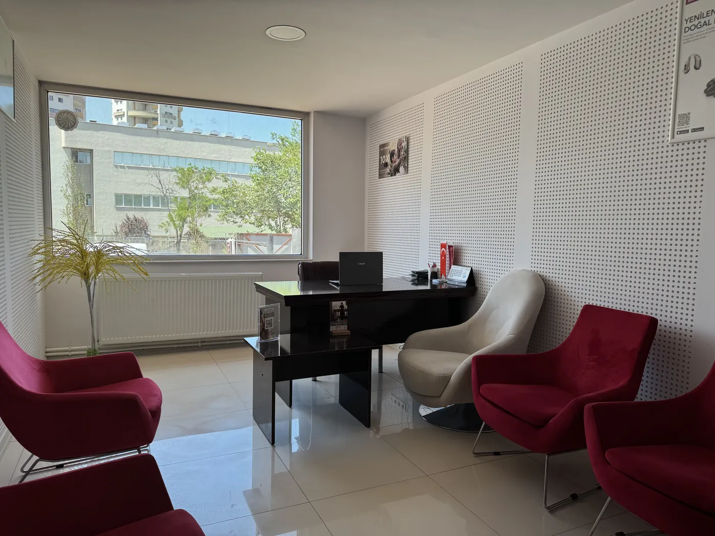 Doruk İşitme Cihazları Ümitköy Şubesi danışma odasında ahşap masa ve bordo koltuklar